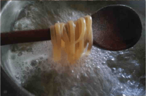 The third step on how to cook pasta by mamma rosy is dropping the pasta to the mixed boiling water