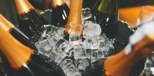Many bottles of champagne and sparkling wine in a bucket of ice cubes